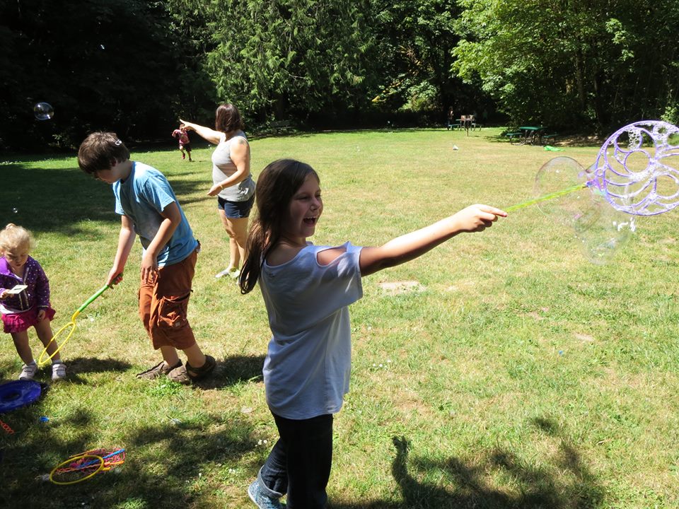 children outdoors playing with bubbles