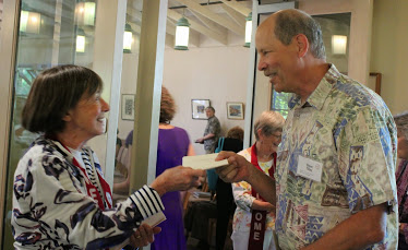 woman handing man a program for that day's service