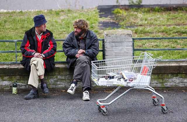 two homeless people sitting and talking