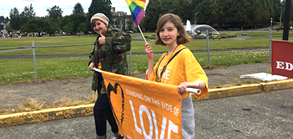 two people carrying a banner that says standing on the side of love