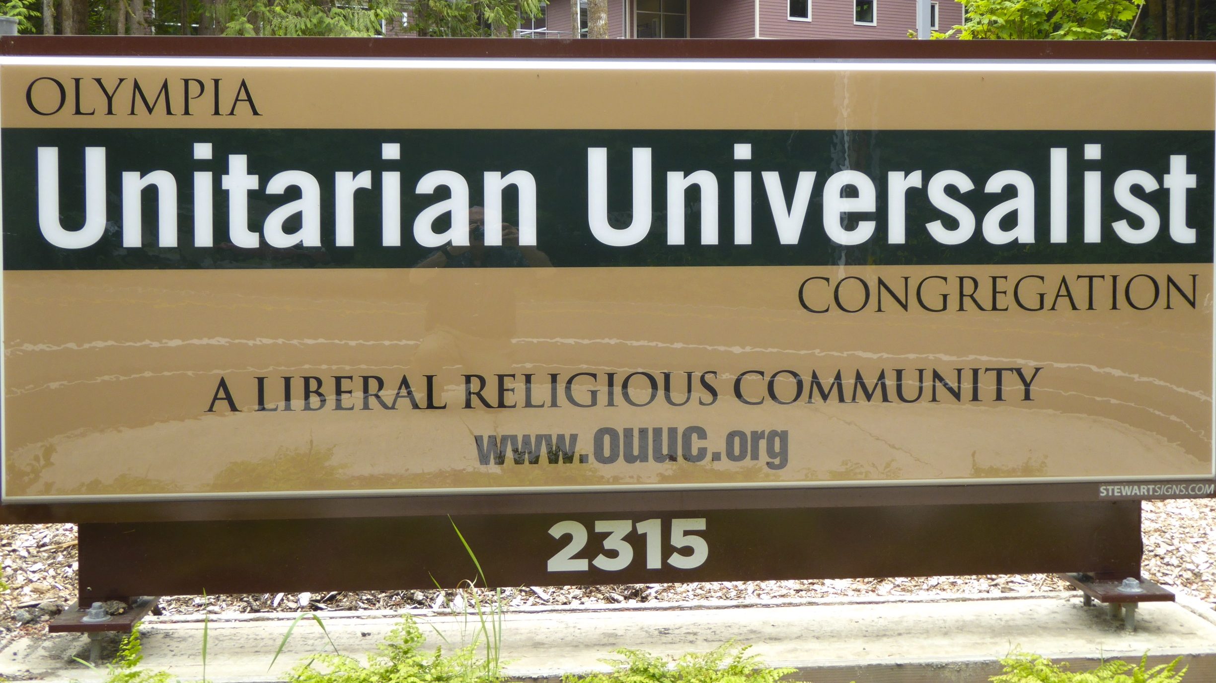The Olympia Unitarian Universalist Congregation sign at the entrance to the parking lot