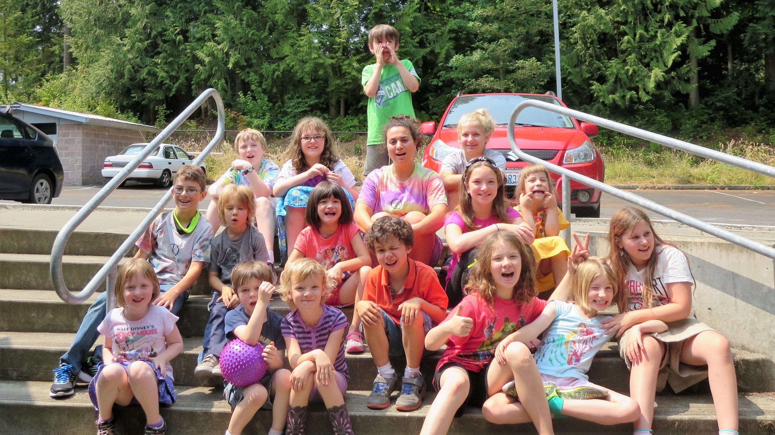 a group of children sitting on outdoors on stairs