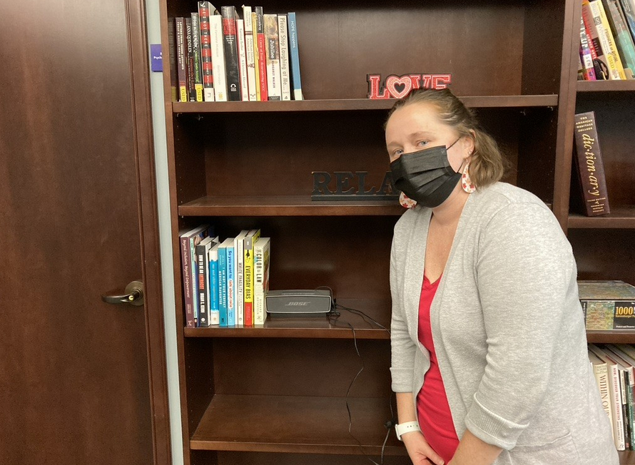 Natalie Skovran stands next to the Family Support Center library 